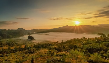 Mountain view morning sea of fog in valley around with forest and man hills with yellow sun light in the sky background, sunrise at Phu Langka Photo Corner View Point, Route 1148, Phayao, Thailand.