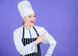 Here is your menu. Culinary expert advertising restaurant menu. Happy female cook pointing finger away and offering menu. Presenting menu list, copy space