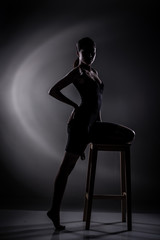 Healthy and Fit Sport Asian Woman in Bodysuit Underwear posing strong and bad feeling weight loss control, black corset body slim dress on asia girl. Studio lighting dark smoke background low exposure