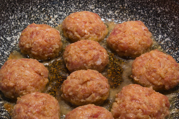 Homemade cooking cutlets in a grey granite frying pan