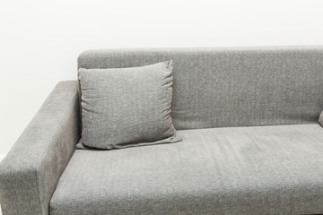 Classic modern gray sofa with pillows in the bright interior of the apartment. Close up