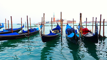Fototapeta premium Moored or docked gondolas near the Saint Mark Square with San Giorgio di Maggiore church