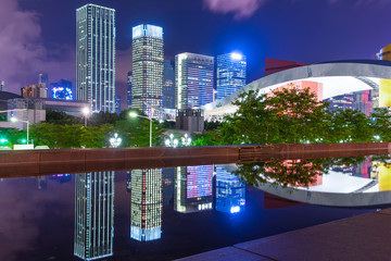 Tall buildings and reflections by the water at night
