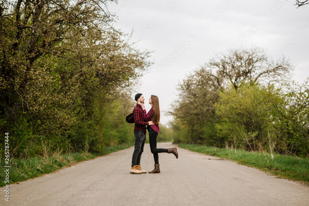 Wall mural happy active couple walking and have fun on the country side road