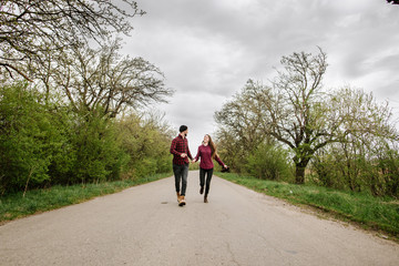 Happy active couple walking and have fun on the country side road