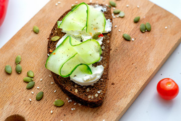 Sandwich with cucumber and seeds on whole grain bread. The concept of healthy eating.