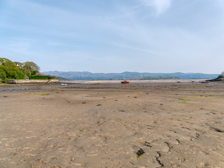 Small boats beached on the soft sand of Borth-y-Gest harbour at low tide.