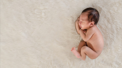 Fototapeta premium infant baby sleeping on white fleece carpet
