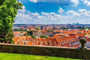 Prague red roofs and dozen spires of historical Old Town of Prague. Cityscape of Prague on a sunny day. Red rooftops, spires and the Charles Bridge and Vltava River in the background. Prague, Czechia.
