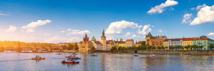 Smetanovo Embankment with Charles Bridge and boats on Vltava river, Prague, Czech Republic....