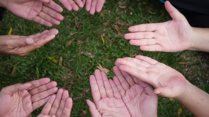 A group of hands holding a red heart.