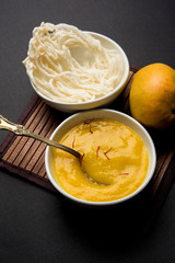 Aam Ras or Alphonso mango pulp with kurdai which is a fried dish made using wheat/gehu. selective focus