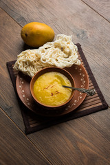 Aam Ras or Alphonso mango pulp with kurdai which is a fried dish made using wheat/gehu. selective focus