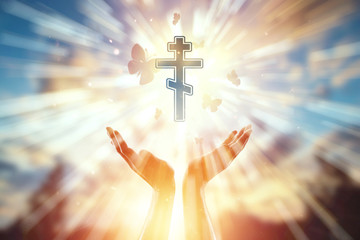 Hands closeup on the background of the symbol of Christianity, prayer, orthodox cross. The concept of religion, hope, faith, a symbol of freedom.