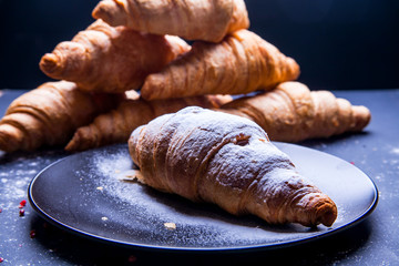 Delicious breakfast with fresh croissants and coffee served with butter and honey.