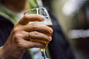 Fototapeta na wymiar man's hand holds a glass of beer in bar