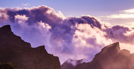 Amazing view of mountain peaks with beautiful clouds on the sunset. Location: Tenerife, Canary Islands, Spain. Artistic picture. Beauty world. Panorama