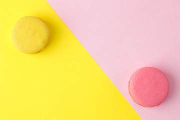 Macarons. french multicolored macaroons cakes. small french sweet cake on a bright multi-colored pink and yellow background. Dessert. Sweets. top view