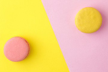 Macarons. french multicolored macaroons cakes. small french sweet cake on a bright multi-colored pink and yellow background. Dessert. Sweets. top view