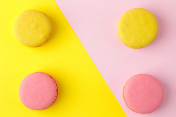 Macarons. french multicolored macaroons cakes. small french sweet cake on a bright multi-colored pink and yellow background. Dessert. Sweets. top view