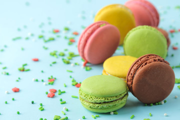 Macarons. french multicolored macaroons cakes. small french sweet cake on bright blue background. Dessert. Sweets.