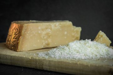 Grated parmesan cheese on black background, italian food.