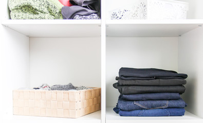 Home wardrobe with different clothes. Small space organization. The contrast of order and disorder.