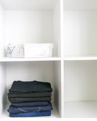 Fototapeta na wymiar Home wardrobe with different clothes. Small space organization. The contrast of order and disorder.