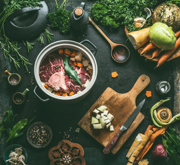 Raw meat in cooking pot on kitchen table background with vegetables , seasoning and kitchen...