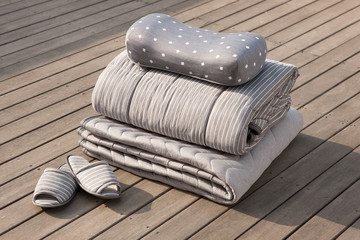 folded grey pillow and blanket on the wood floor.