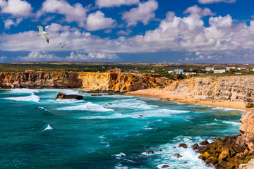 Panorama view of Praia do Tonel (Tonel beach) in Cape Sagres, Algarve, Portugal. Seagulls flying over Praia Do Tonel, beach located in Alentejo, Portugal. Ocean waves on Praia Do Tonel beach.