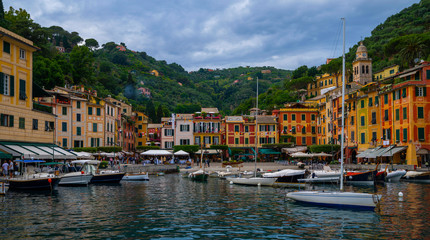 Fototapeta na wymiar Famous place on the Ligurian coast is Portofino with colorfull houses, luxury boats and yachtes in little harbor surrounded stunning botanical garden decorated with mediterranean flowers. Italy.