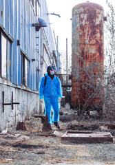 Fototapeta na wymiar man environmental mask face pack disguise facemask bitmask protective overall blue orange rast plant factory disused catastrophe