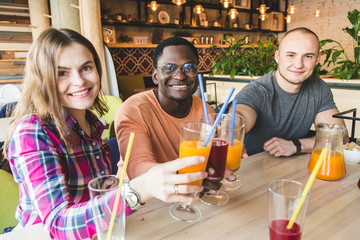 A company of young people having fun, drinking drinks, cocktails, juices in a cafe. Meeting best friends