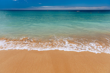 Blue ocean wave on sandy beach. Soft wave of blue ocean on sandy beach. Background. Top view of Beautiful beach with tranquil wave, sea and ocean background, summer vacation concept.