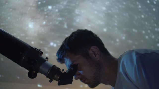 Astronomer Man in moonlight looking at sky using telescope with stars swirling