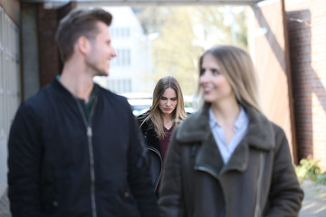 Junges Paar während junge Frau traurig schaut