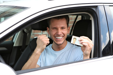 Junger Mann freut sich über seinen Führerschein