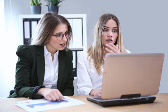 Zwei Gesch&auml;ftsfrauen schauen erschrocken auf einen Computerbildschirm