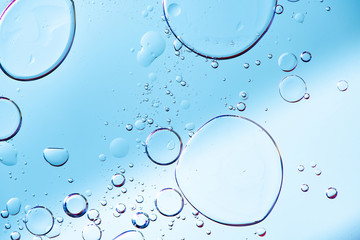 Beautiful macro photo of water droplets in oil with a blue background.