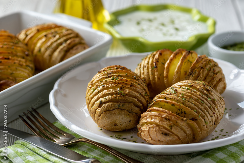 Wall mural hasselback potatoes baked with garlic and herbs in oven.