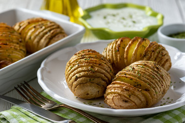 Hasselback potatoes baked with garlic and herbs in oven.