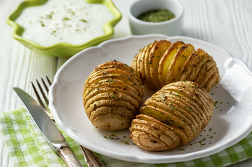 Hasselback potatoes baked with garlic and herbs in oven.