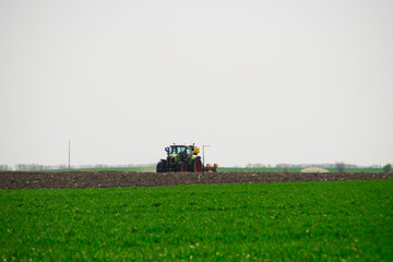 Fototapeta premium Tractor plows a field in the spring