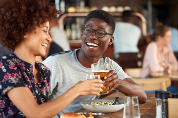 Couple On Date Meeting For Drinks And Food Making A Toast In Restaurant