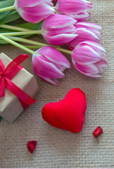 Plakat Tulips and red heart on brown cloth Background.