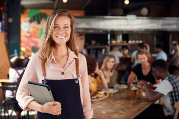 Foto op Plexiglas Portret van serveerster met menu& 39 s die dienen in drukke bar-restaurant © Monkey Business