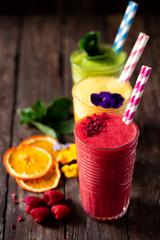 Smoothies of delicious taste decorated with green leaves, fruit slices and fruits