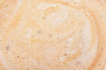 Delicate foam of freshly brewed aromatic coffee with bubbles and beautiful patterns on the surface