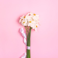 Seasonal flowers in a minimalistic bouquet on a bright background.